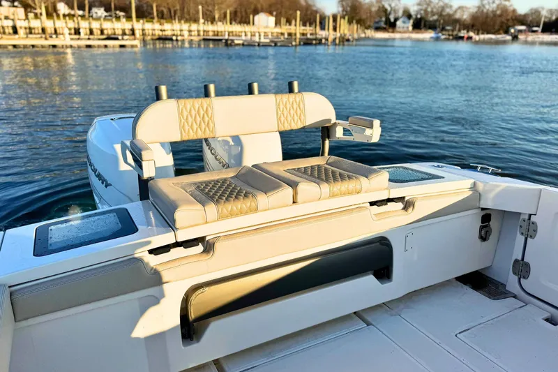 Slide: The Image of 2023 Solace 32 CS boat interior with cushioned seating and water view. - 8