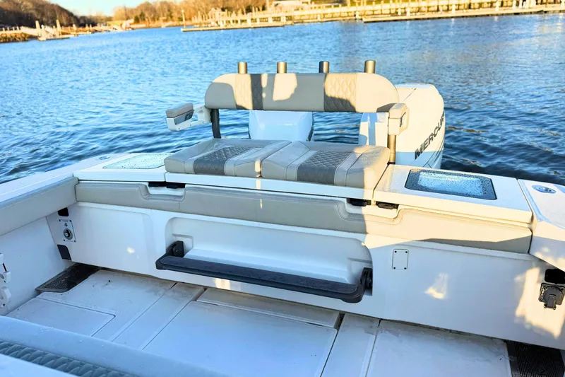 Slide: The Image of 2023 Solace 32 CS boat interior, featuring sleek seating and storage, overlooking calm waters. - 9