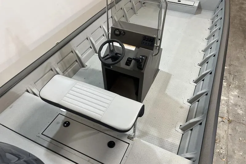 Slide: The Image of 2025 SeaArk 2472 CUB boat interior with steering console and seating. - 6