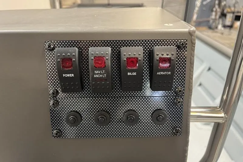 Slide: The Image of Control panel of 2025 SeaArk 2472 CUB boat with labeled switches. - 8