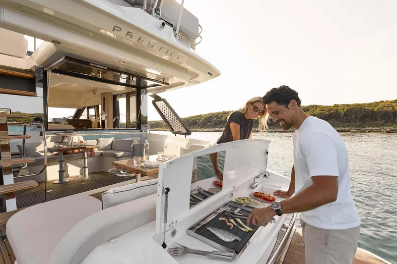 Slide: The Image of Manufacturer Provided Image: Couple enjoying barbecue on 2026 Prestige F4.3 yacht, with scenic ocean backdrop. - 5