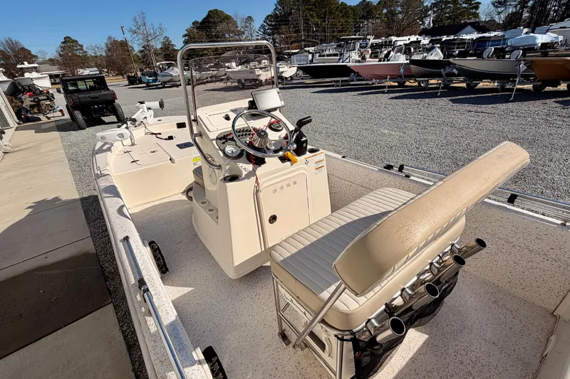 Slide: The Image of 2018 Carolina Skiff 18 JVX CC boat interior with console and seating, parked outdoors. - 7