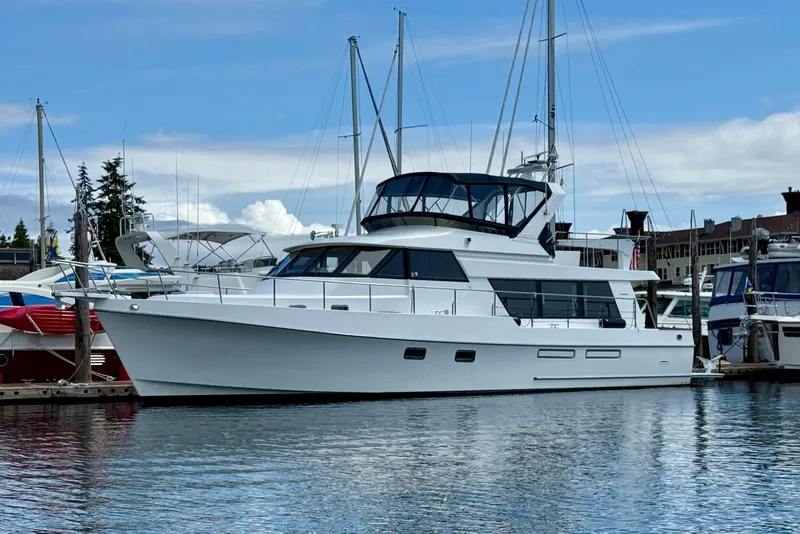 Slide: The Image of 1997 Ocean Alexander 486 Pilothouse yacht docked in a marina under a blue sky. - 1