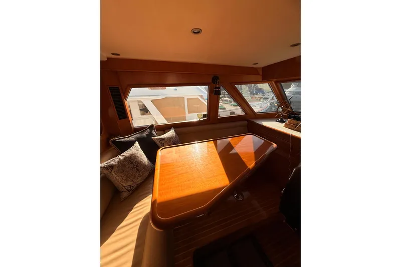 Slide: The Image of Luxurious interior of 1997 Ocean Alexander 486 Pilothouse yacht with wooden table and cushions. - 14