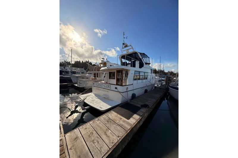 Slide: The Image of 1997 Ocean Alexander 486 Pilothouse yacht docked under a bright sky. - 2