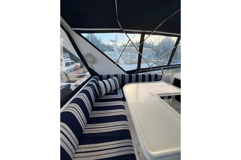 Slide: The Image of Interior of 1997 Ocean Alexander 486 Pilothouse with striped seating and table. - 21