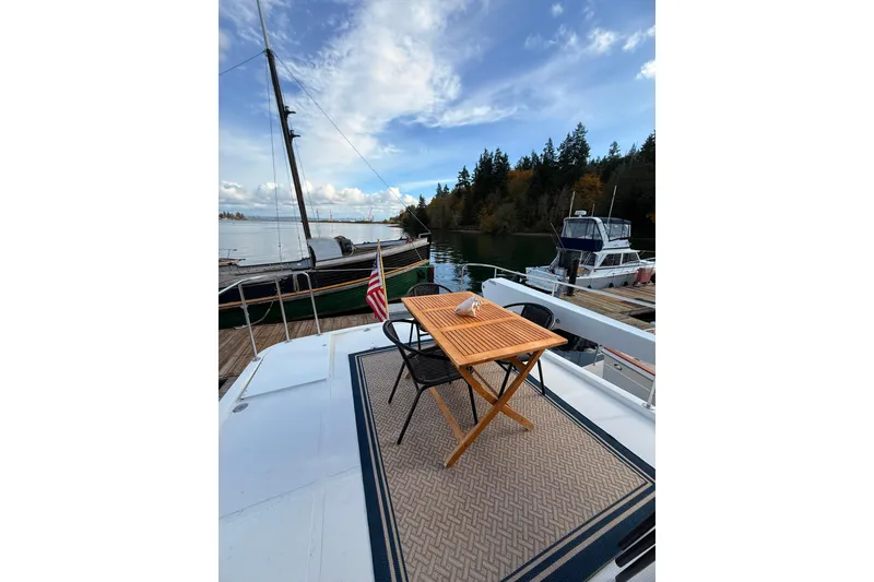 Slide: The Image of 1997 Ocean Alexander 486 Pilothouse yacht with outdoor seating, docked in scenic marina. - 22