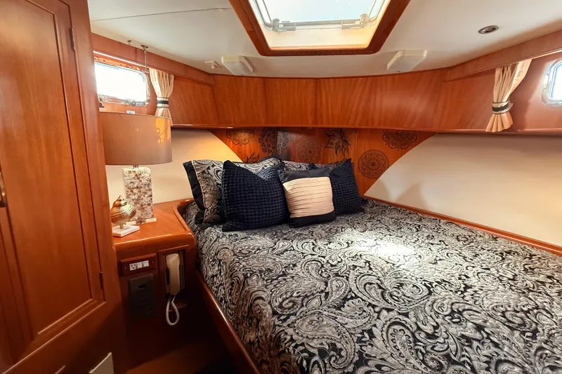 Slide: The Image of Luxurious 1997 Ocean Alexander 486 Pilothouse bedroom with elegant bedding and wood accents. - 28