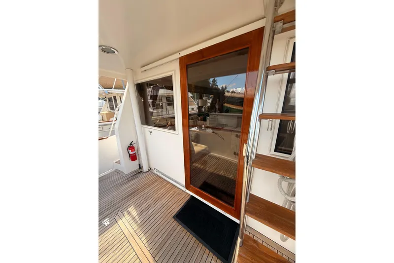 Slide: The Image of 1997 Ocean Alexander 486 Pilothouse yacht with wooden deck and glass door entry. - 4