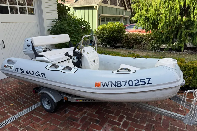 Slide: The Image of Apex inflatable boat "TT Island Girl" on trailer, parked on brick driveway. - 45