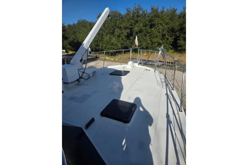 Slide: The Image of 1988 Symbol 44' Sportfish boat deck with railing and equipment, surrounded by trees. - 12
