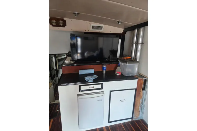 Slide: The Image of Interior of 1988 Symbol 44' Sportfish yacht with wood flooring and compact kitchen area. - 20