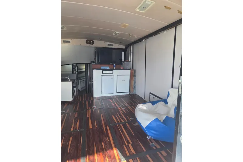 Slide: The Image of Interior view of a 1988 Symbol 44' Sportfish boat, featuring seating and a doorway. - 21
