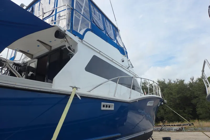 Slide: The Image of 1988 Symbol 44' Sportfish boat with blue and white exterior, docked outdoors. - 4