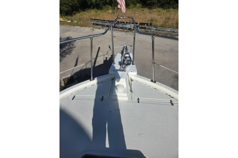 Slide: The Image of 1988 Symbol 44' Sportfish boat with blue tarp and fishing rod setup. - 12