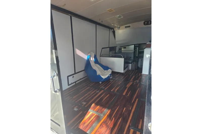 Slide: The Image of Interior view of a 1988 Symbol 44' Sportfish boat, featuring seating and a doorway. - 20