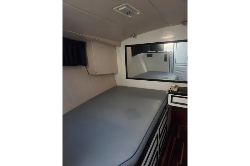 Slide: The Image of 1988 Symbol 44' Sportfish cabin interior with bed and storage. - 25