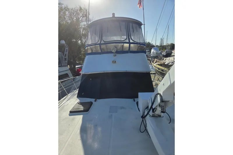 Slide: The Image of 1988 Symbol 44' Sportfish boat with blue and white exterior, docked outdoors. - 3
