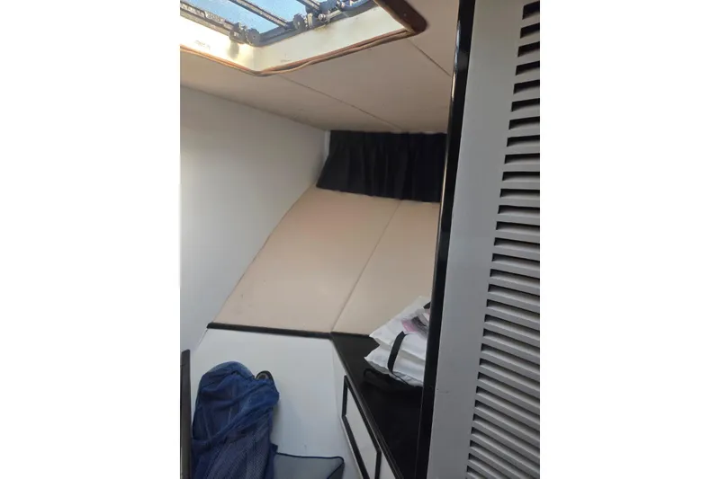 Slide: The Image of 1988 Symbol 44' Sportfish boat with blue hull, docked outdoors under clear sky. - 30