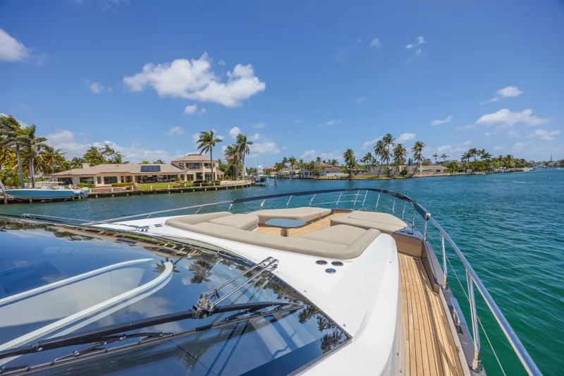 Slide: The Image of 2023 Azimut S8 yacht cruising on a sunny day with palm trees in the background. - 16