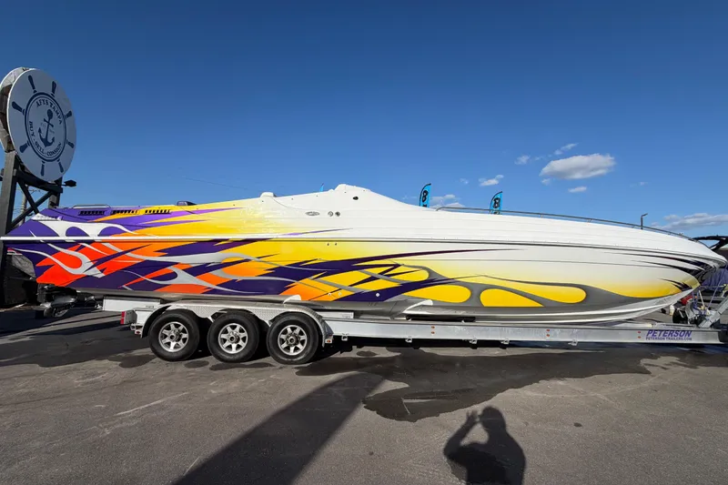 Slide: The Image of 1999 Black Thunder XT-430 speedboat with vibrant flame graphics on a trailer. - 1