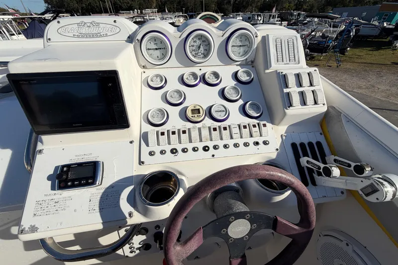 Slide: The Image of Control panel of a 1999 Black Thunder XT-430 powerboat with gauges and steering wheel. - 19