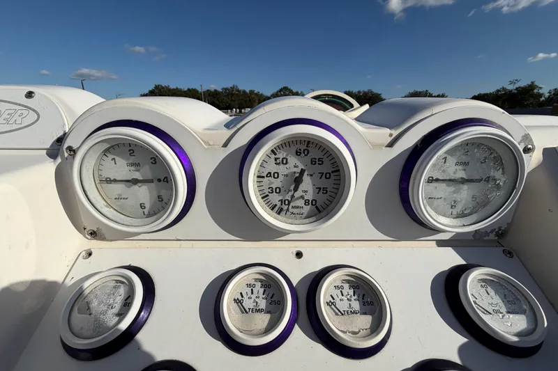 Slide: The Image of Dashboard of a 1999 Black Thunder XT-430 boat with gauges under a clear sky. - 21