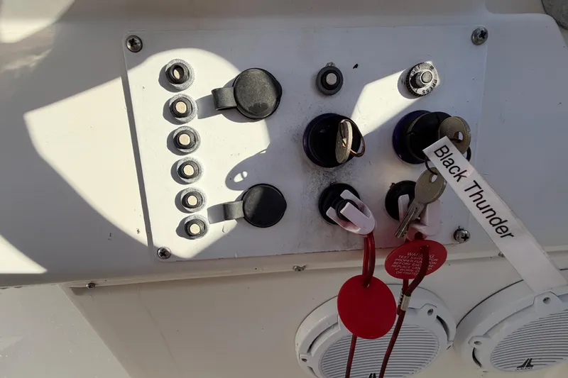 Slide: The Image of Control panel of a 1999 Black Thunder XT-430 boat with keys and switches. - 24