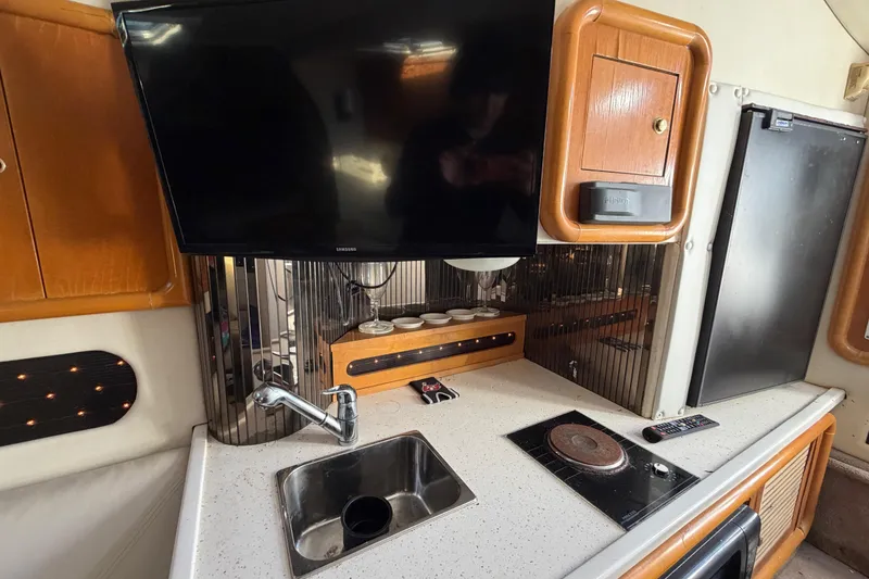 Slide: The Image of 1999 Black Thunder XT-430 interior with kitchenette, TV, sink, and stove. - 31