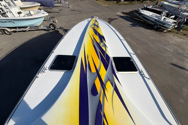 Slide: The Image of Aerial view of 1999 Black Thunder XT-430 boat with vibrant yellow and purple design. - 33