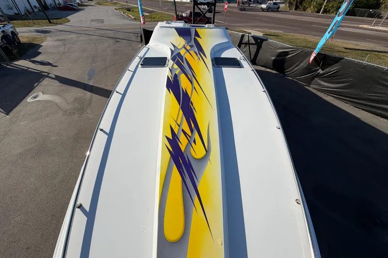 Slide: The Image of 1999 Black Thunder XT-430 boat with vibrant yellow and purple graphics on deck. - 34