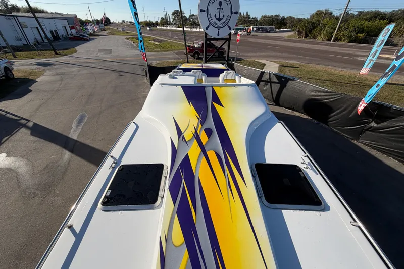 Slide: The Image of 1999 Black Thunder XT-430 boat with vibrant yellow and purple graphics on deck. - 35