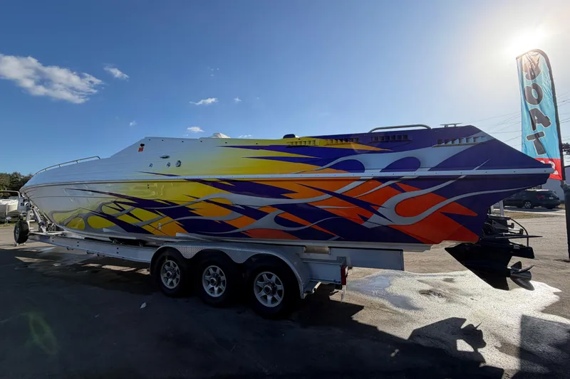 Slide: The Image of 1999 Black Thunder XT-430 boat with vibrant flame graphics on a trailer. - 5