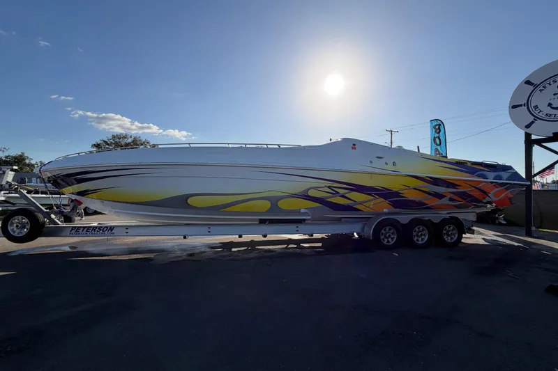 Slide: The Image of 1999 Black Thunder XT-430 boat with vibrant yellow and orange design on trailer. - 6
