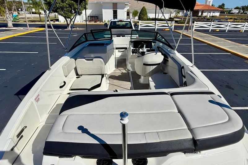 Slide: The Image of 2023 Sea Ray SPX 210 Outboard boat interior with seating and steering wheel. - 23