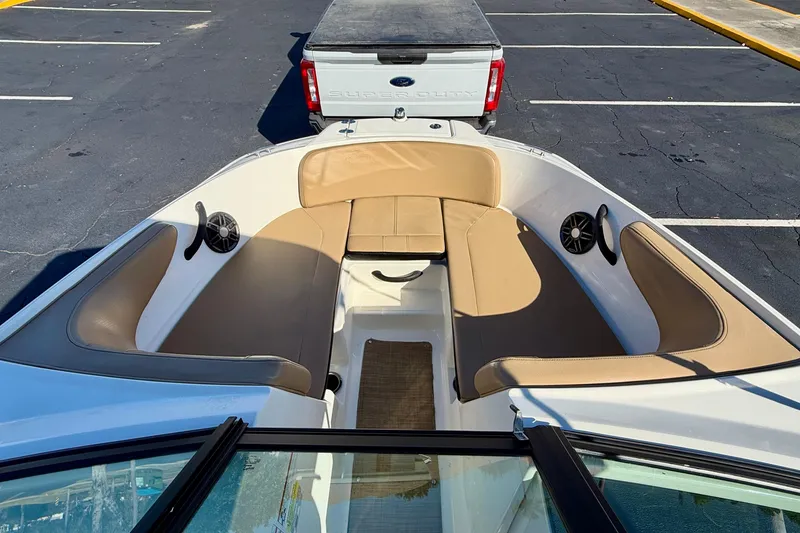 Slide: The Image of 2022 Sea Ray SPX 210 Outboard boat interior with tan seating and speakers. - 11
