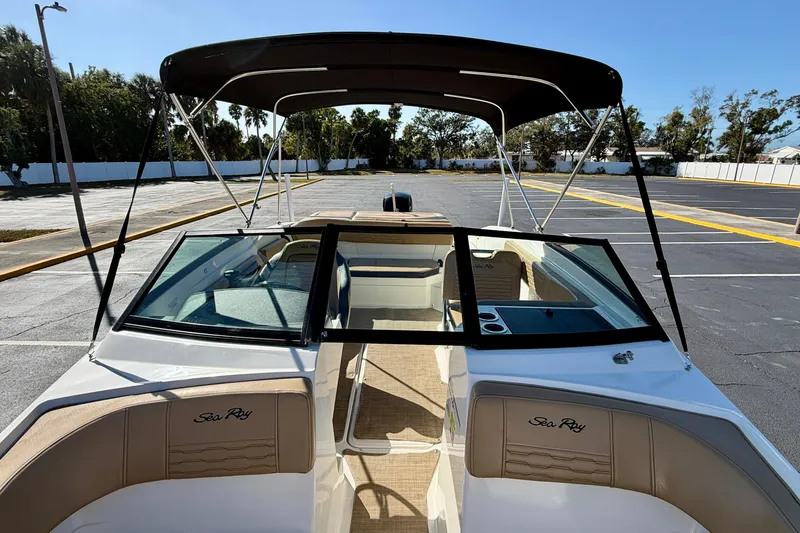 Slide: The Image of 2022 Sea Ray SPX 210 Outboard boat with canopy, parked in a sunny lot. - 12