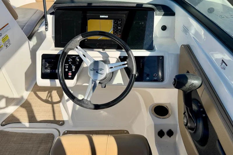 Slide: The Image of 2022 Sea Ray SPX 210 Outboard dashboard with steering wheel and controls. - 17
