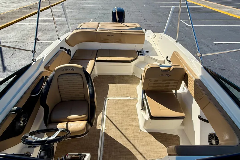 Slide: The Image of 2022 Sea Ray SPX 210 Outboard boat interior with tan seating and steering wheel. - 21