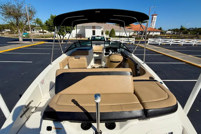 Slide: The Image of 2022 Sea Ray SPX 210 Outboard boat with tan seating and canopy in a parking lot. - 26