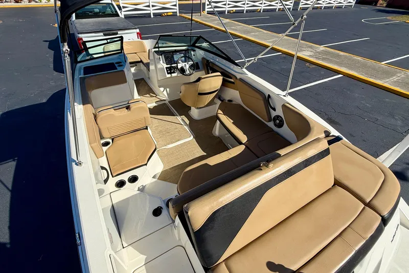 Slide: The Image of 2022 Sea Ray SPX 210 Outboard boat interior with tan seating and steering console. - 27