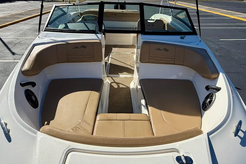 Slide: The Image of 2022 Sea Ray SPX 210 Outboard boat interior with tan seating and black accents. - 8