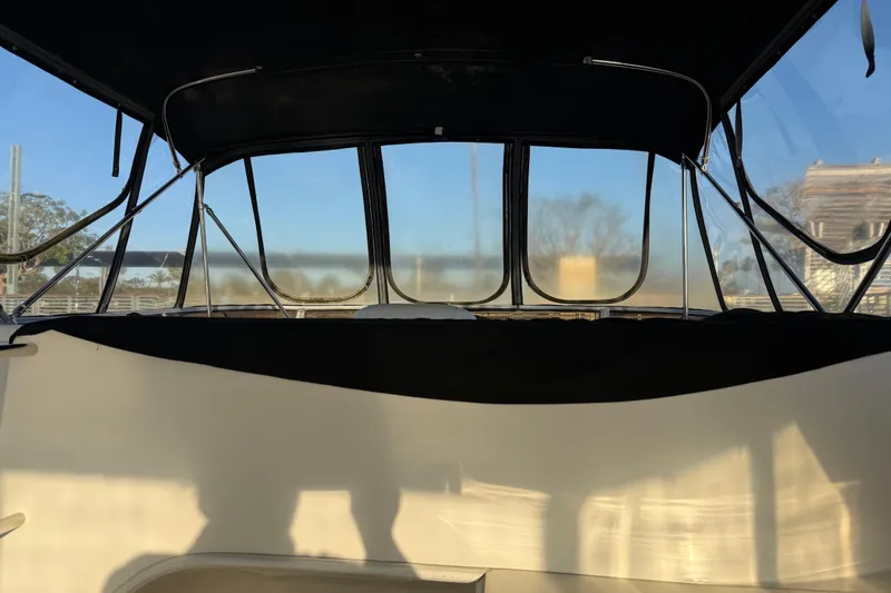 Slide: The Image of 2007 Meridian 459 Motoryacht interior with clear windows and black canopy. - 13