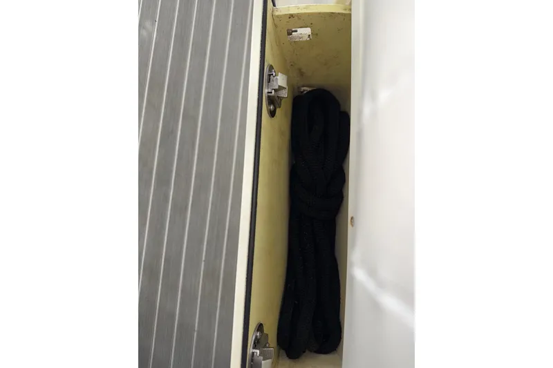 Slide: The Image of Storage compartment with black rope on a 2014 Mako 284 Center Console boat. - 11