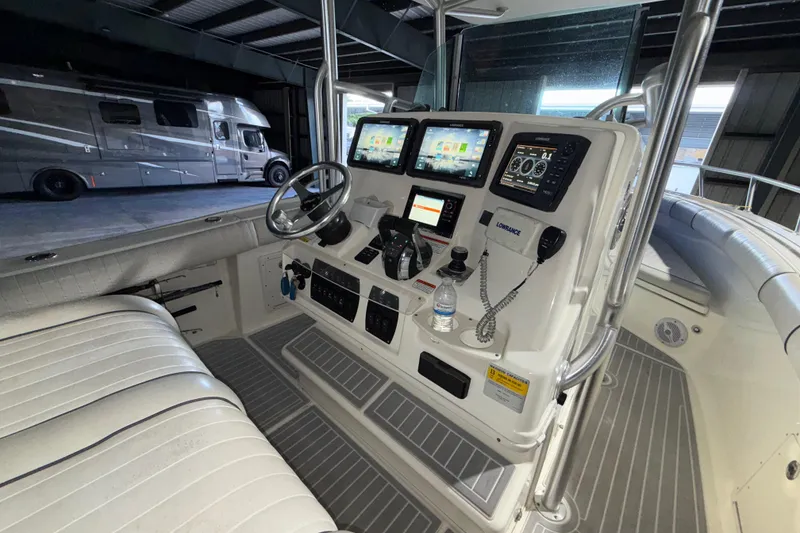 Slide: The Image of 2014 Mako 284 Center Console boat interior with advanced navigation systems and controls. - 14
