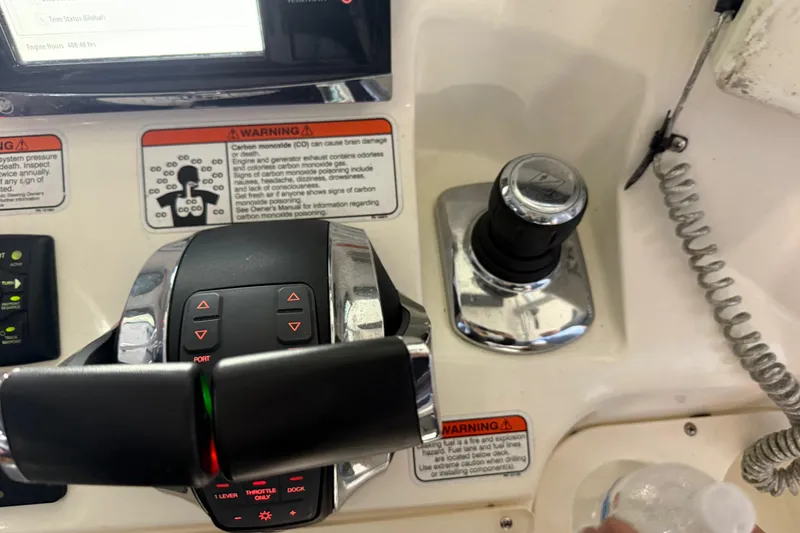 Slide: The Image of Close-up of 2014 Mako 284 Center Console boat controls and warning labels. - 20