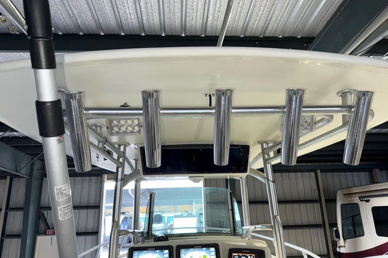 Slide: The Image of 2014 Mako 284 Center Console boat with rod holders and navigation equipment. - 22