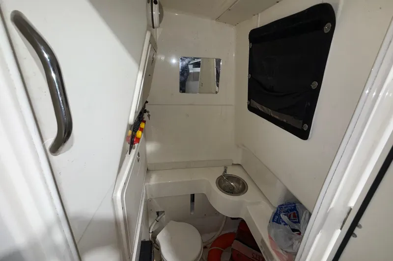 Slide: The Image of Interior of 2014 Mako 284 Center Console boat with compact bathroom amenities. - 23