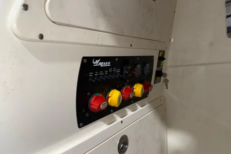 Slide: The Image of Control panel of a 2014 Mako 284 Center Console boat with switches and dials. - 25