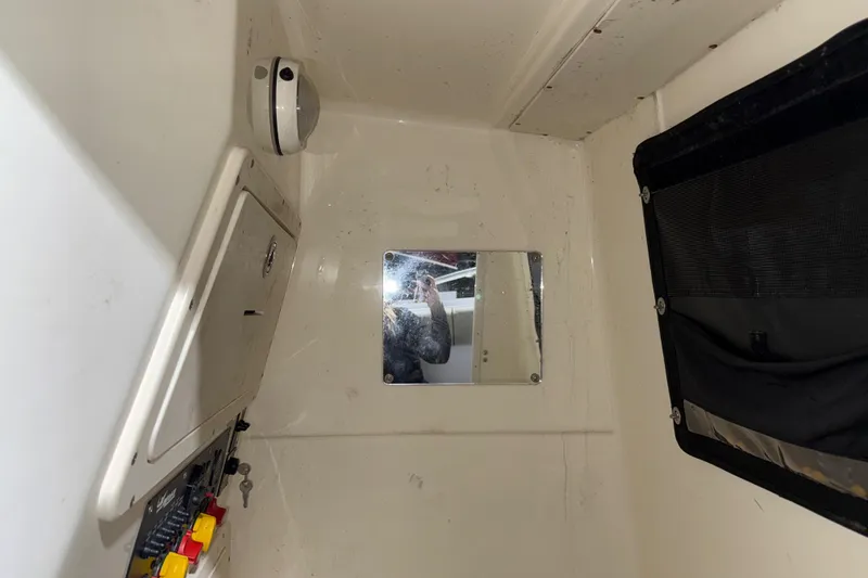 Slide: The Image of Interior of a 2014 Mako 284 Center Console boat with control panel and mirror. - 26